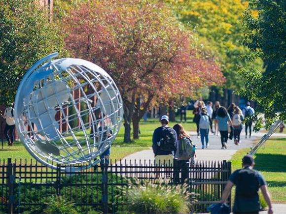 Students walk past the Campus Globe sculpture on the Westfield State University campus.