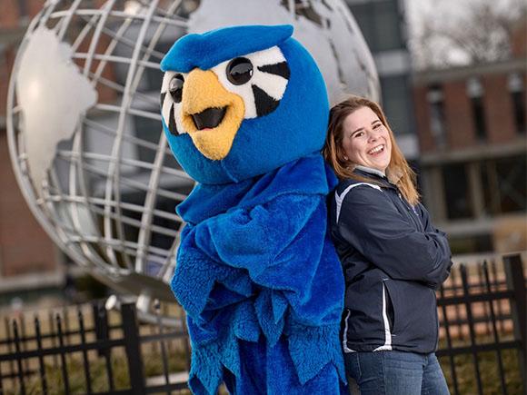 The Westfield State University mascot and student in front of campus globe.