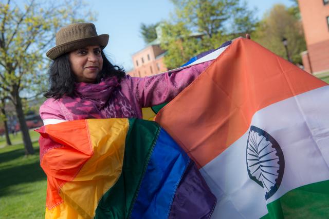 Professor Shoba Rajgopal displaying a Pride flag and the national flag of India