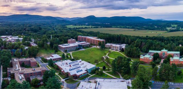An arial view of the Westfield State University campus, with mountains, forests, and fields in the background.