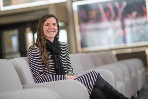 Bethany Mather, a teacher at Farmington River Regional School and alumna of Westfield State University, was recently named this year’s Massachusetts University Educator Alumni Award recipient. She's sitting in the lobby at Horace Mann, in a gray chair. An unfocused window is behind her.