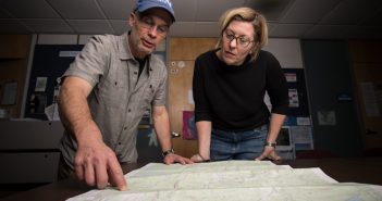 Westfield State University faculty member Carsten Braun (l) and student Stacey Dakai looking over a traditional 2D paper map in the GIS office at the University.