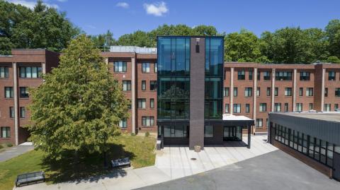 A drone image one of Davis Hall, with brick walls and a glass front.