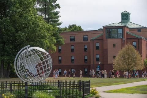 A photo of the campus globe, with a group of students walking in a group faded in the background against Dickinson Hall.