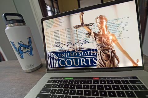 Montage image of a white water tumbler with a blue Westfield State University logo next to a laptop on a desk showing an image of computer code, a statue of the scales of justice and the logo for the United States Courts system.