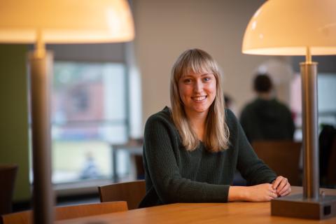 Ailish Ferrick smiling in campus library.