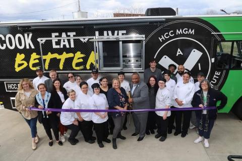 A food truck at Holyoke as part of their initiative to promote healthy eating. Stacy Graves '05, Facility Coordinator for the Culinary Arts Institute at Holyoke Community College, stands around a crowd of her students who will be in charge of the truck.