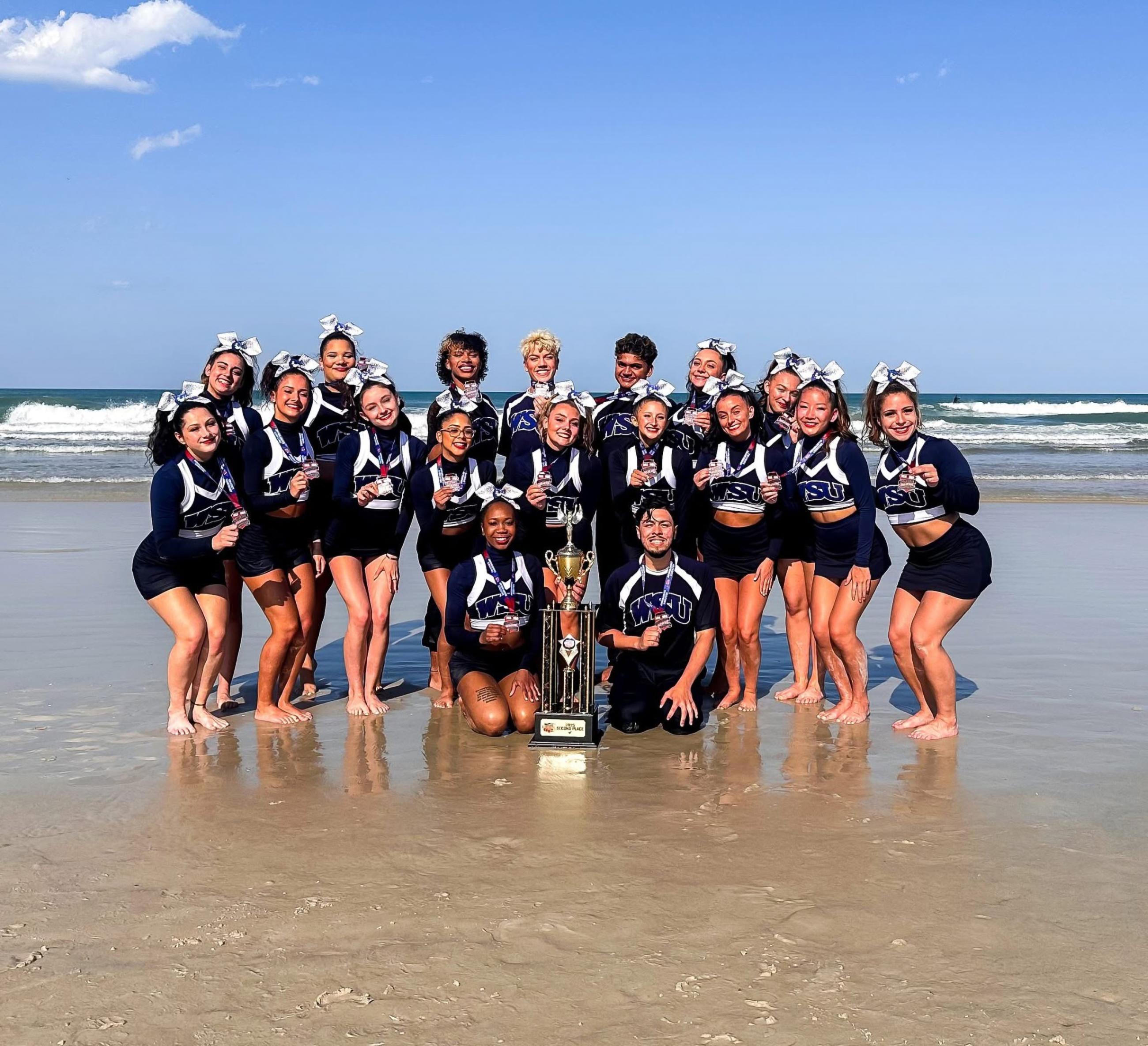 Westfield State University Cheer Team poses on the Florida beach with their medals and trophy