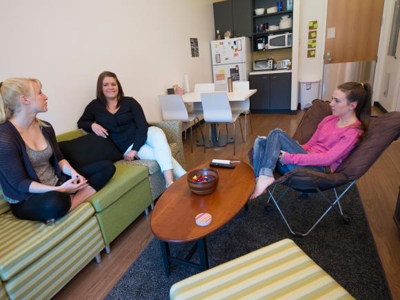 Students talking in the living room of their University Hall dorm room