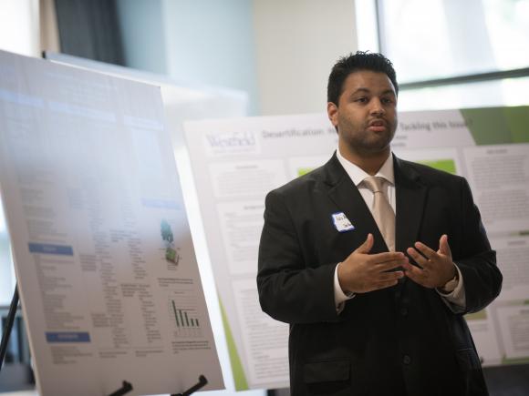 Male student in suit and tie, presents his research during a presentation