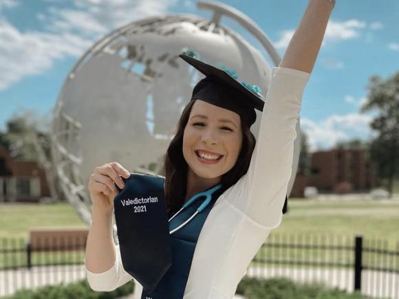 Photo of Hannah Griswold, WSU 2021 Valedictorian in front of the Globe sculpture on the campus green