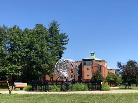 image of the globe on the campus green with Courtney Hall in the background