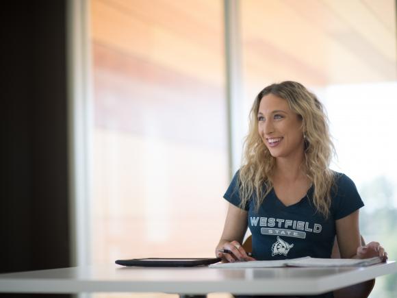 Image of WSU student Lindsey Dalrtmple smiling, seated in front of a large window