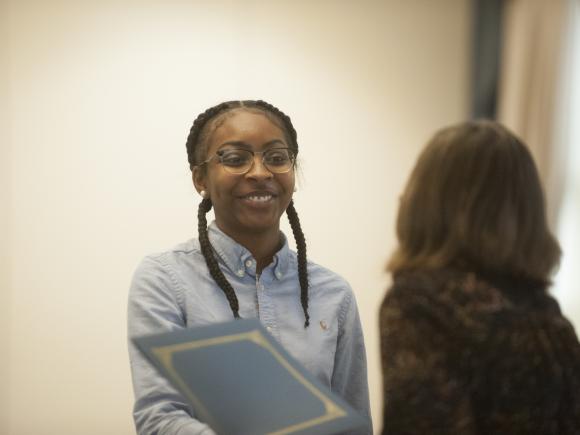 Smiling female student being presented and award during the English Department's Spring Gathering event