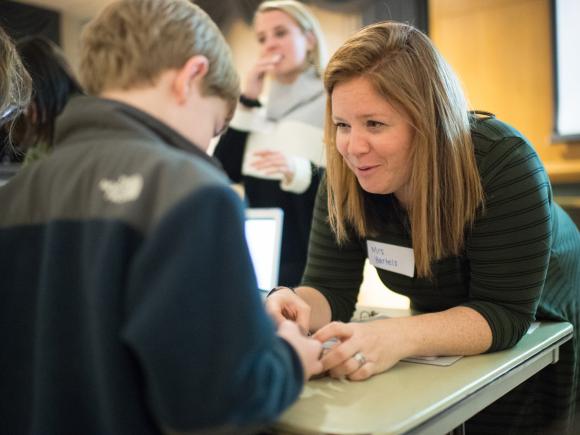 A female education student works with a student from a local elementary school