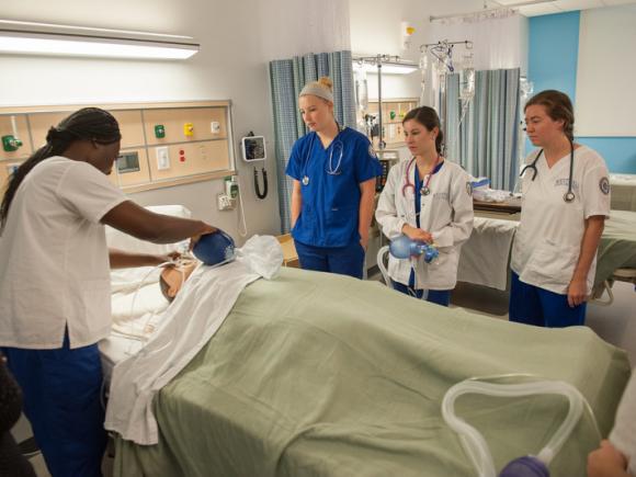 Nursing students demonstrate how to properly bag a patient in the simulation lab