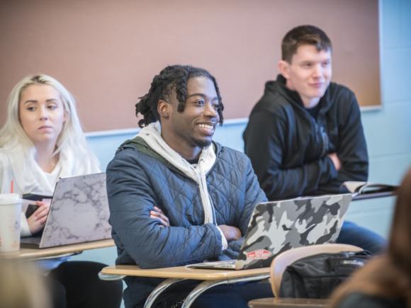 Smiling male student in classroom