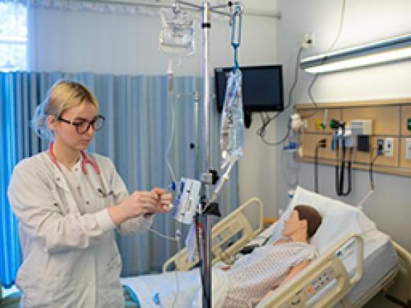 A student nurse administers an IV pump
