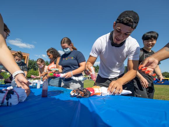 Students tie dye shirts on the green