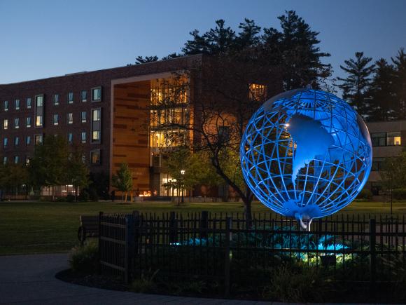 Globe Illuminated Blue with University Hall in Background