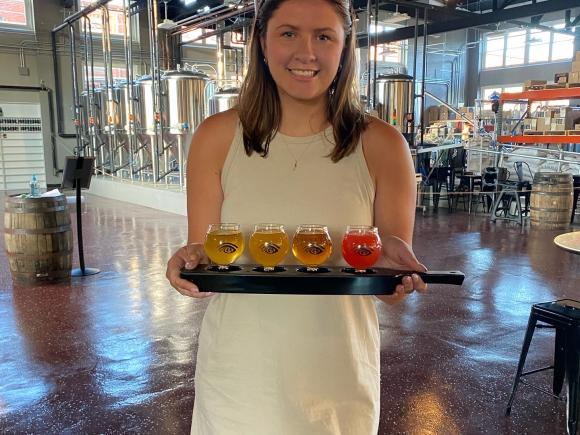 Westfield State student Madeline LeBlanc stands holding a tray of beverages