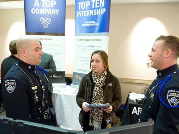 A student talks to two officers from the sheriff’s department at an event.