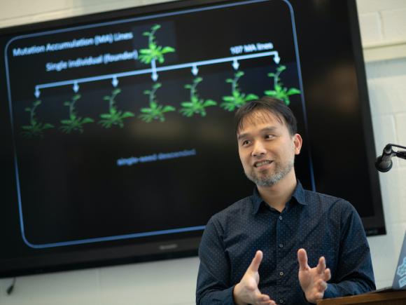 Dr. Weng in front of a TV presenting his research.