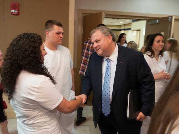 Steve Marcus shakes a student's hand.