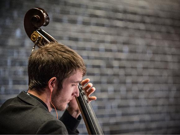 A student in profile plays the string bass.