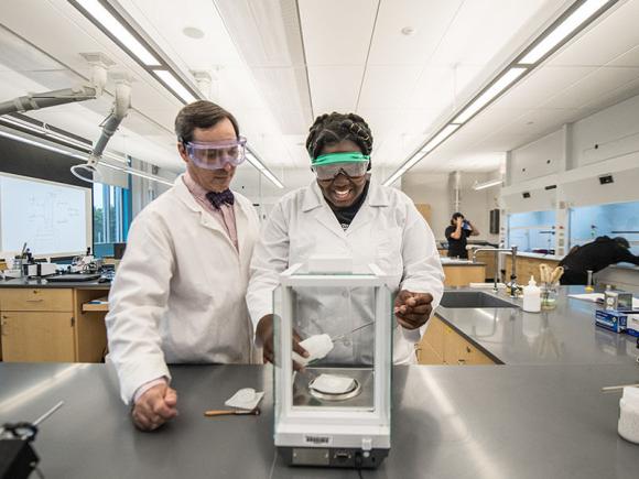Multiple students and their professor work in a laboratory.