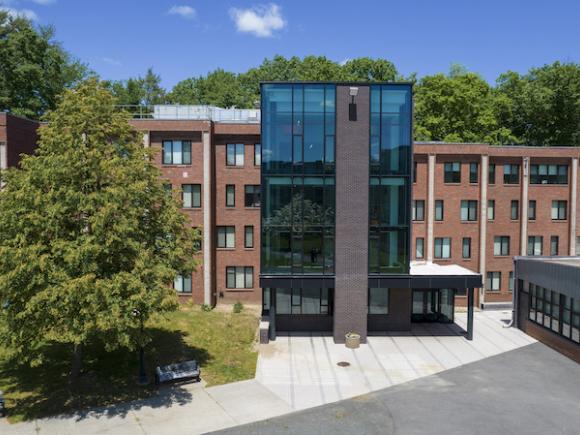 A drone image one of Davis Hall, with brick walls and a glass front.