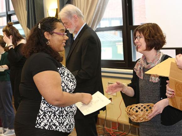 A student prepares to shake a faculty’s hand after receiving a certificate.