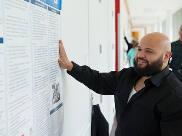 A student reads information displayed on a poster.