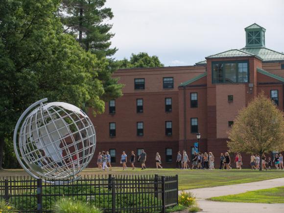 A photo of the campus globe, with a group of students walking in a group faded in the background against Dickinson Hall.