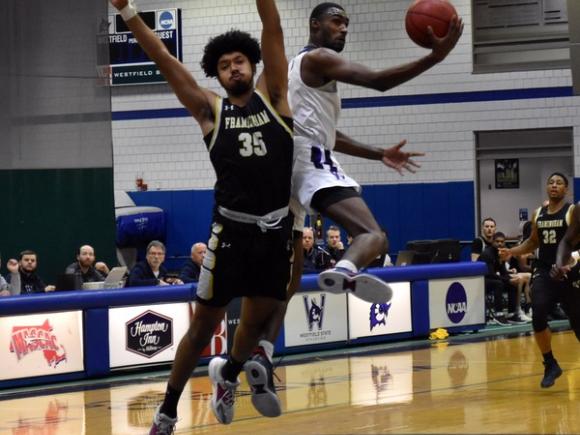 Two basketball players jump to make a shot