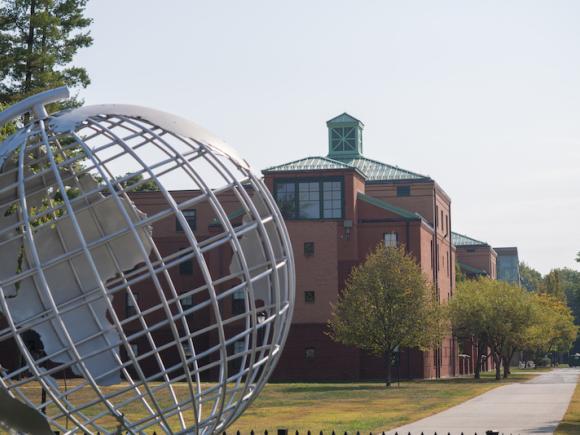 A photo of the campus' silver globe, shot in front of University Hall in the background.