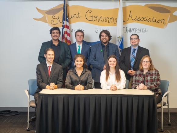 SGA Executive Council featuring 8 students with Student Government banner behind them.