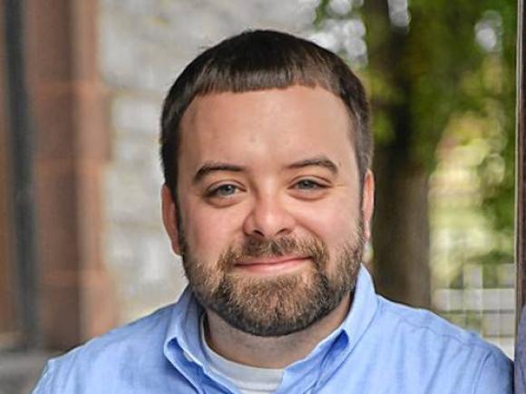 Joe member of the Western Mass Writing Project wearing light blue collared shirt smiling.