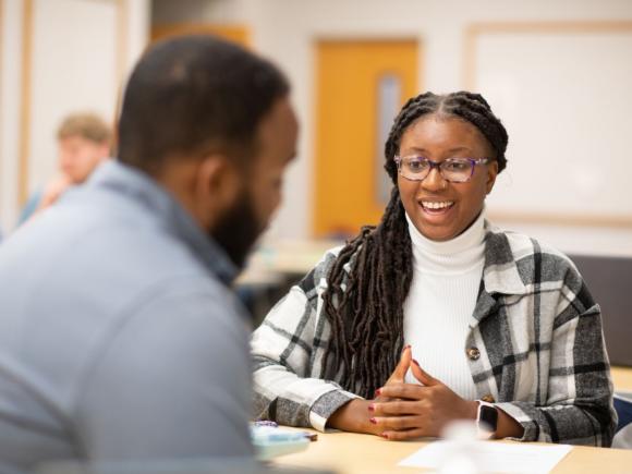 Two Westfield State University students engage in discussion in a classroom.