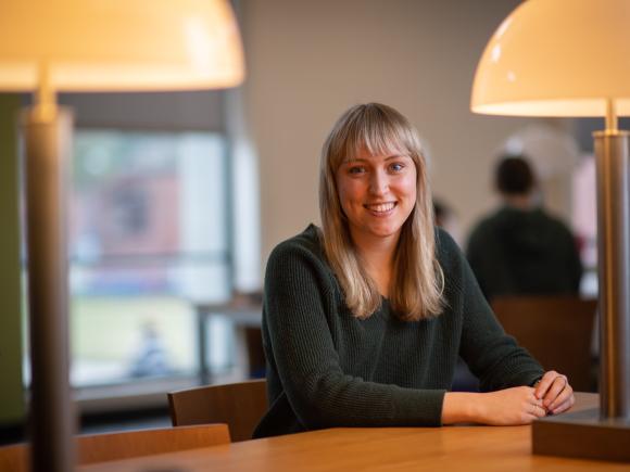 Ailish Ferrick smiling in campus library.