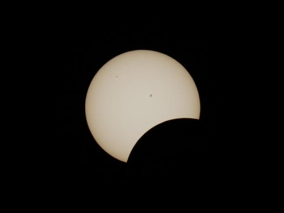 A close-up photo of the 2024 total solar eclipse, taken by Christopher Masi, Professor of Chemical and Physical Sciences. The photo is completely dark besides the sun and the moon, which is a shadow and edges towards the middle of the sun.