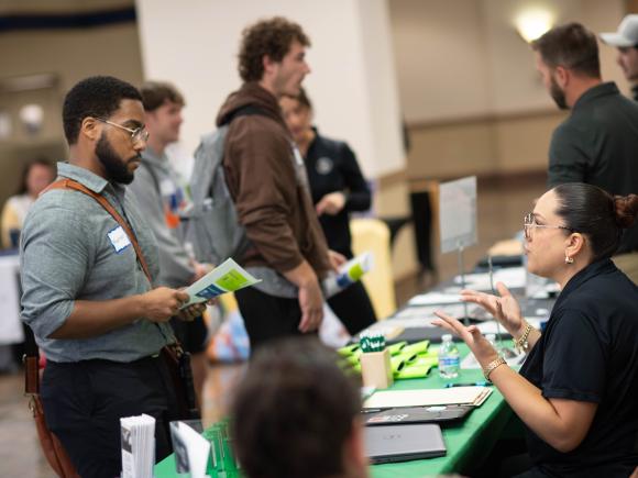 Students talk to people at tables