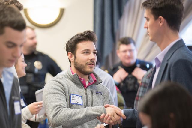 Male student shakes hands with a prospective employer at the career fair