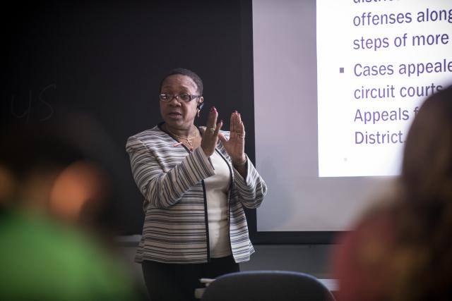 CJ professor lecturing in class in front of a projection screen