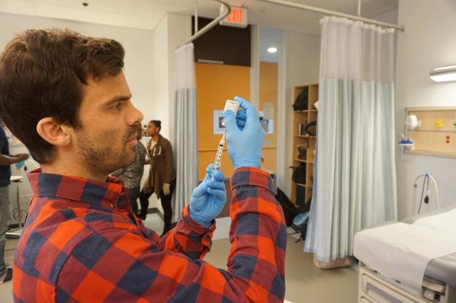 A male student fills a syringe in the Sim lab in the Stevens Science Center