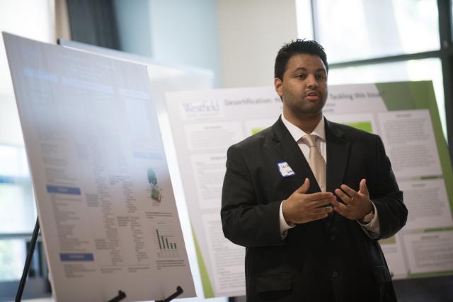 Male student in suit and tie, presents his research during a presentation