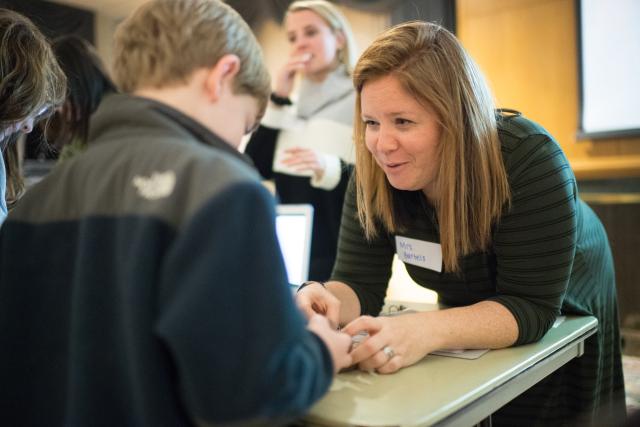 A female education student works with a student from a local elementary school