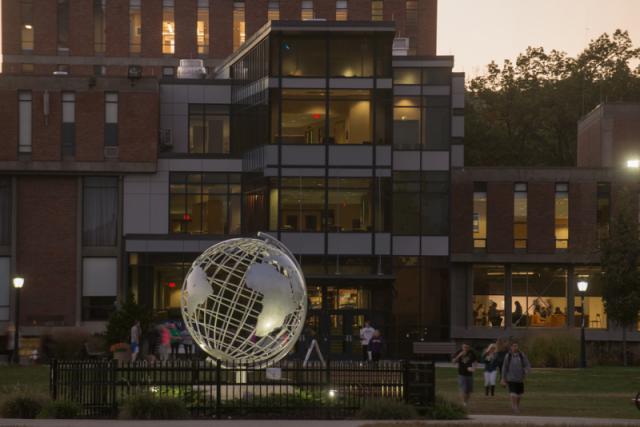 Globe on the campus green during early evening, with the Campus Center in the background