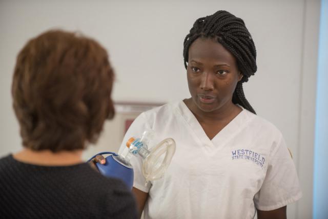 A female nursing student listens to one of her instructors