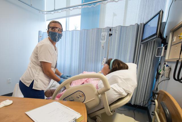 Phot of Westfield State Nursing student working with a simulated patient in the Sim Lab